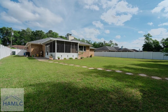 view of yard with a fenced backyard and a sunroom