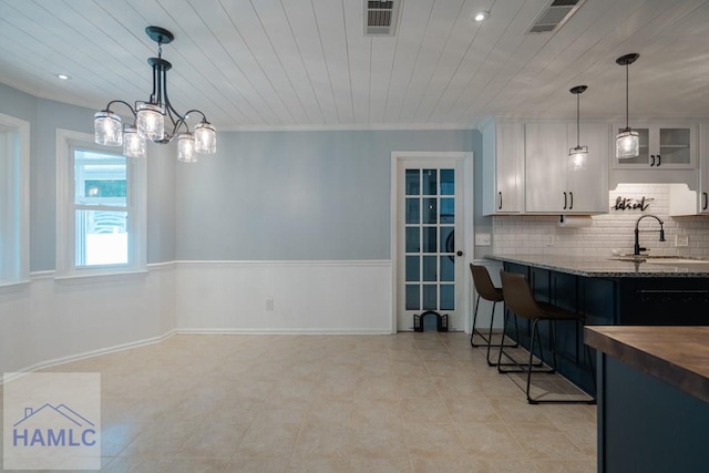 kitchen featuring a chandelier, visible vents, backsplash, and a sink