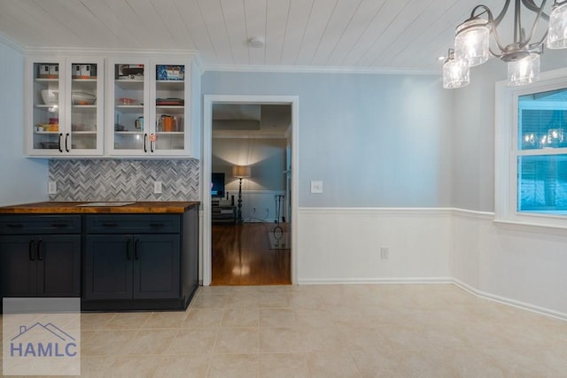 unfurnished dining area with wooden ceiling, light tile patterned floors, a notable chandelier, and crown molding