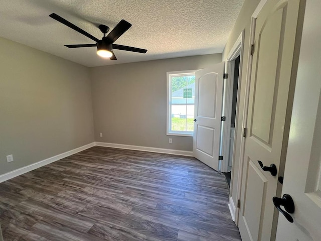 unfurnished bedroom featuring a textured ceiling, ceiling fan, and dark wood-type flooring