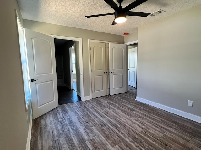 556 Caleb Cir, Jesup, GA 31545 - unfurnished bedroom with a textured ceiling, dark wood-type flooring, baseboards, a closet, and ensuite bathroom