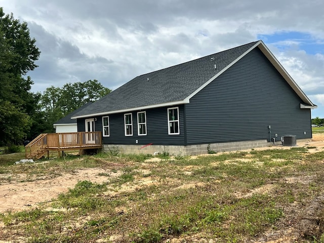 rear view of house featuring central AC unit and a wooden deck