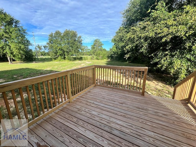 wooden terrace featuring a yard