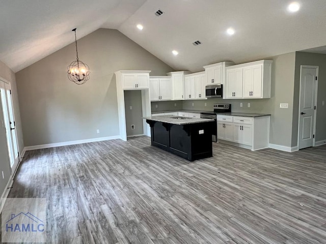 kitchen with a center island, white cabinets, light wood-type flooring, and appliances with stainless steel finishes