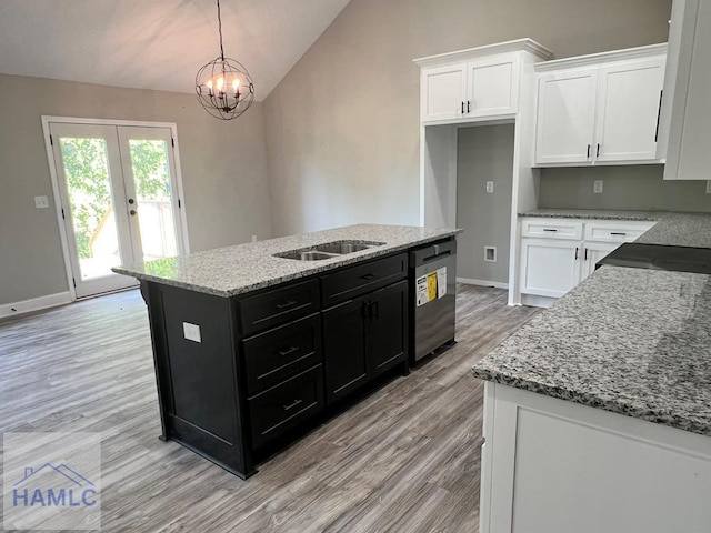 kitchen with pendant lighting, white cabinetry, dishwasher, a kitchen island, and lofted ceiling