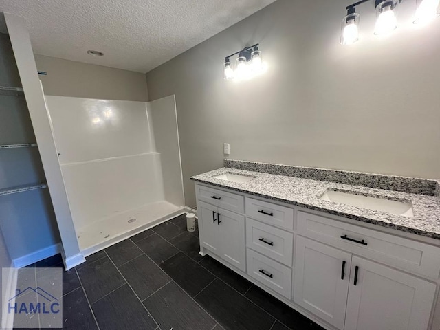 556 Caleb Cir, Jesup, GA 31545 - bathroom with a textured ceiling, a walk in shower, and double vanity