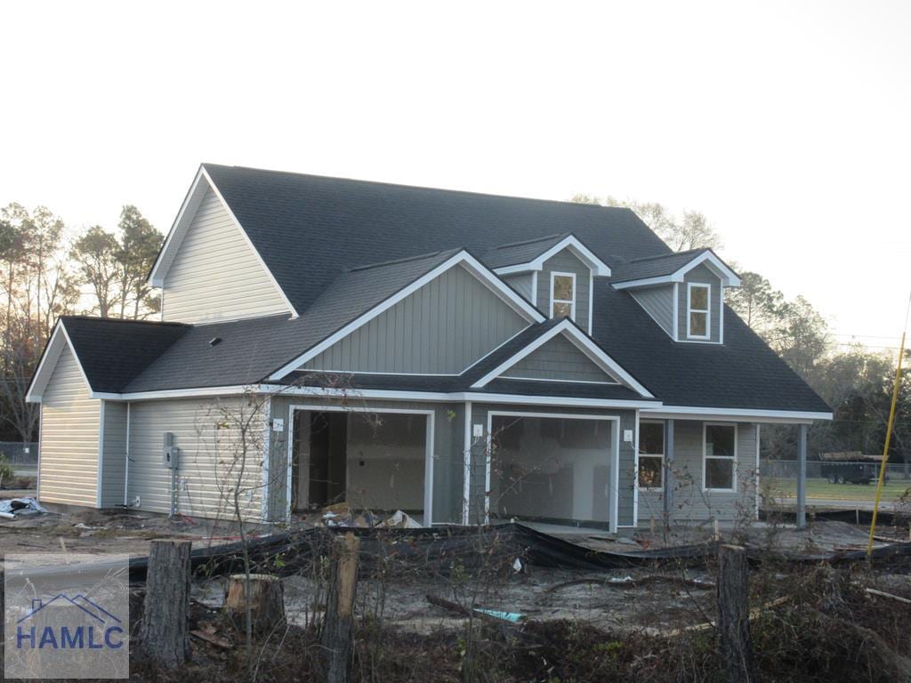 view of front of house with a garage and a shingled roof