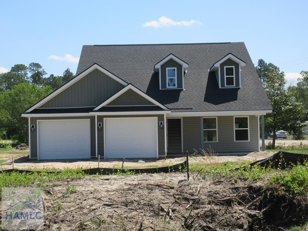 view of front facade featuring roof with shingles and driveway