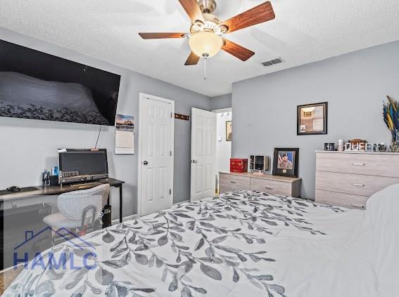 bedroom with a textured ceiling and ceiling fan