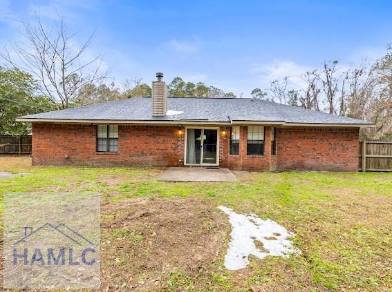 back of property with a lawn and a patio