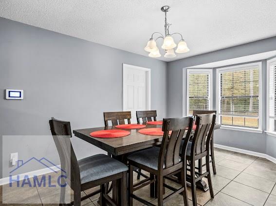 dining area with a chandelier, a textured ceiling, and light tile patterned floors