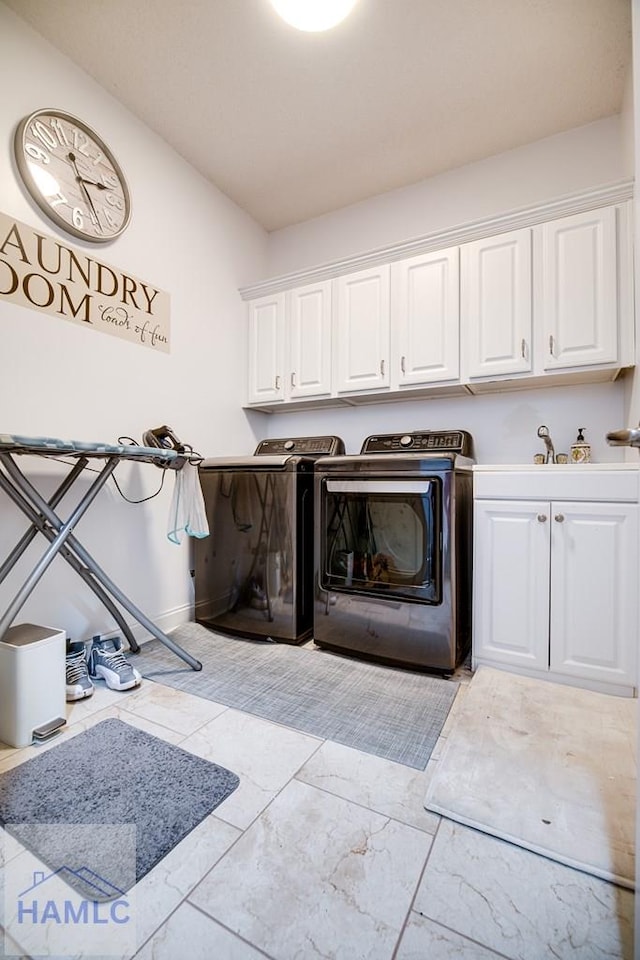 washroom featuring washer and dryer, sink, and cabinets