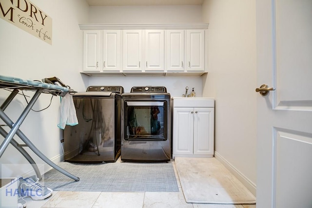 clothes washing area with cabinets, independent washer and dryer, light tile patterned flooring, and sink