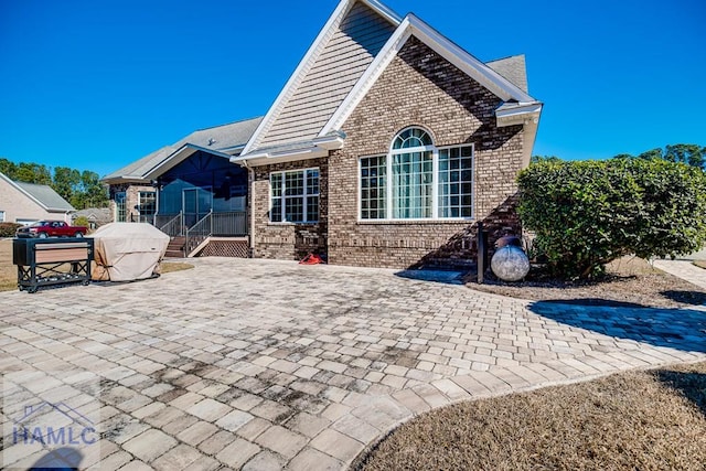 rear view of property featuring a patio area and a sunroom