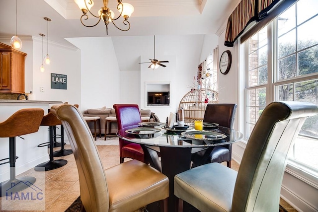 dining area featuring a raised ceiling, a wealth of natural light, and ornamental molding