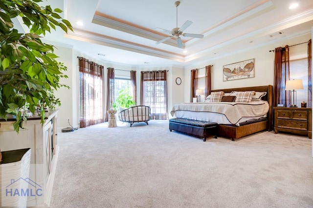 bedroom featuring a raised ceiling, crown molding, ceiling fan, and light colored carpet