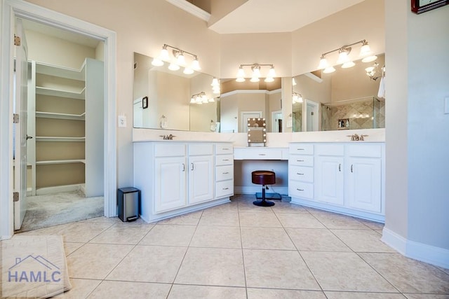 bathroom with tile patterned flooring, vanity, tiled shower, and crown molding