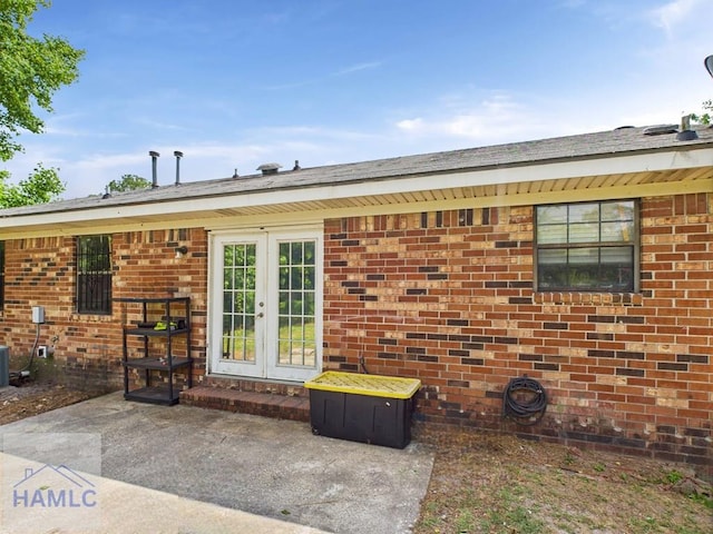 back of property featuring french doors, brick siding, and a patio area