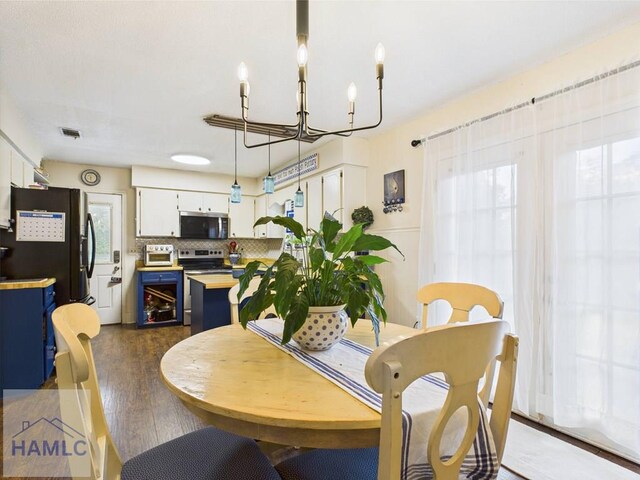 dining space with a chandelier and dark wood finished floors