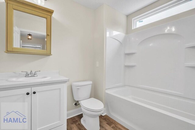 full bathroom with toilet, vanity, shower / bathtub combination, and hardwood / wood-style flooring