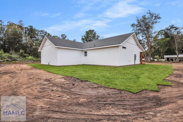 view of side of home with a yard