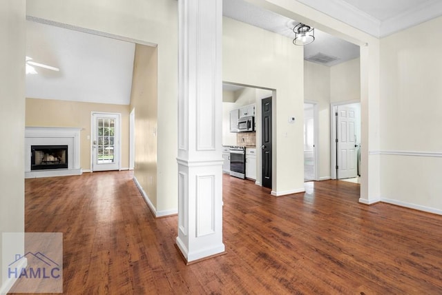 hall featuring baseboards, visible vents, dark wood finished floors, a high ceiling, and ornate columns