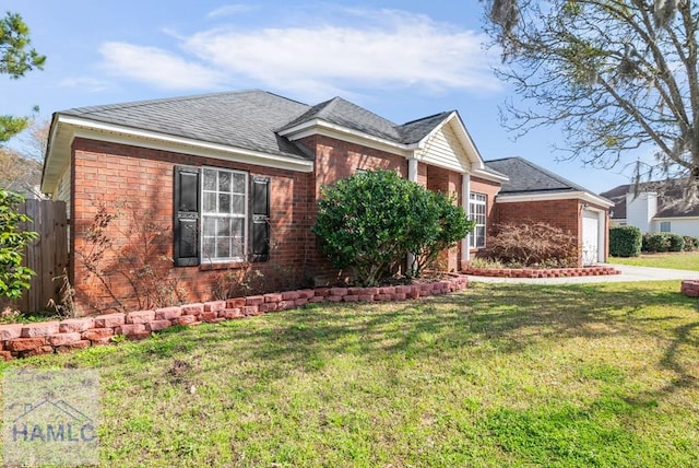 view of front of home featuring a garage, brick siding, fence, and a front lawn