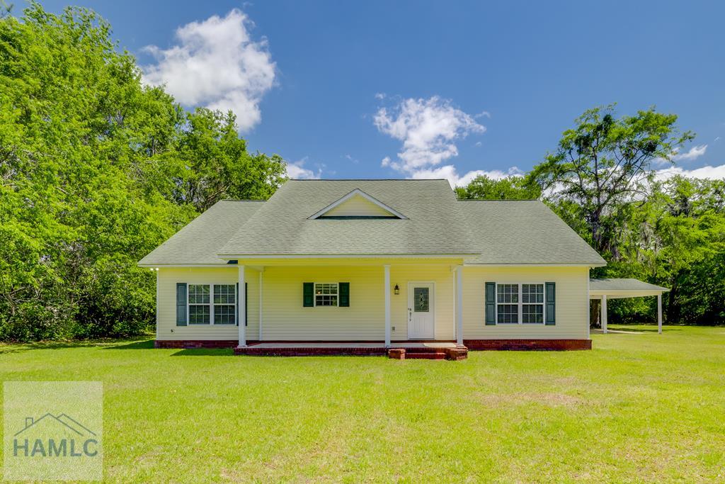 192 Lexie Ln, Fleming, GA 31309 - view of front of home with a porch, a front yard, and an attached carport