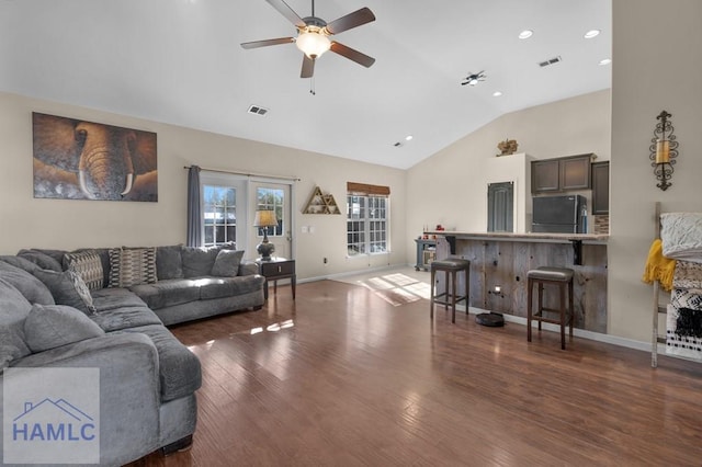 living room featuring dark wood-type flooring, ceiling fan, and high vaulted ceiling