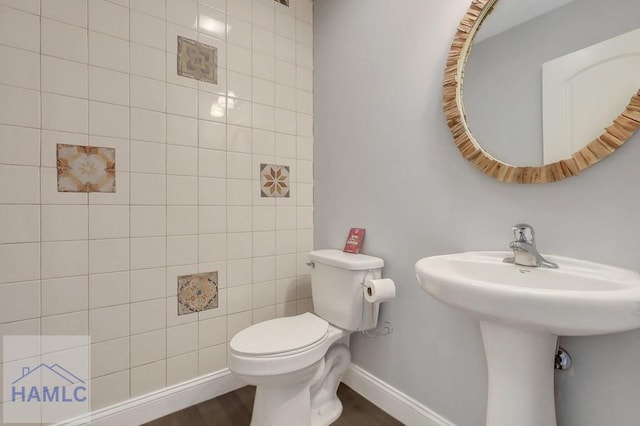 243 Forest St, Ludowici, GA 31316 - bathroom featuring toilet, baseboards, a sink, and wood finished floors