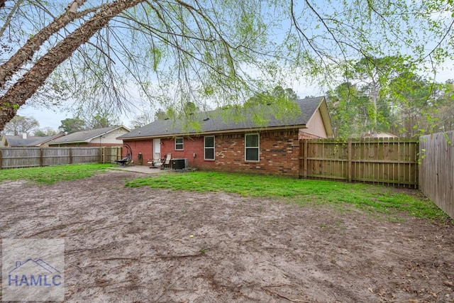 124 Deann Dr, Hinesville, GA 31313 - rear view of house with cooling unit, a patio, brick siding, and roof with shingles