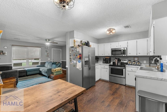 124 Deann Dr, Hinesville, GA 31313 - kitchen with appliances with stainless steel finishes, a sink, light countertops, dark wood-style floors, and a textured ceiling
