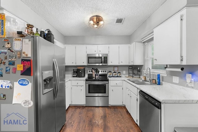 124 Deann Dr, Hinesville, GA 31313 - kitchen featuring appliances with stainless steel finishes, a sink, a textured ceiling, light countertops, and dark wood-style floors