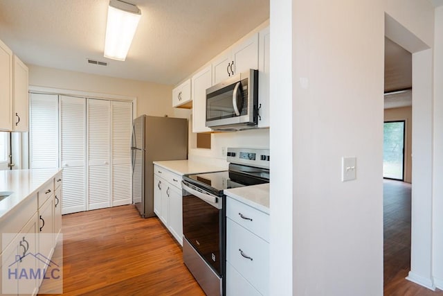 727S Main St Unit 121, Hinesville, GA 31313 - kitchen featuring stainless steel appliances, light countertops, light wood-style flooring, and white cabinetry