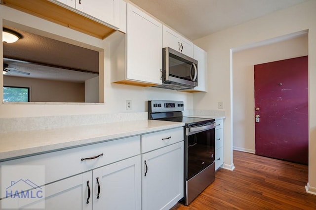 727S Main St Unit 121, Hinesville, GA 31313 - kitchen featuring appliances with stainless steel finishes, light countertops, dark wood finished floors, white cabinets, and a ceiling fan