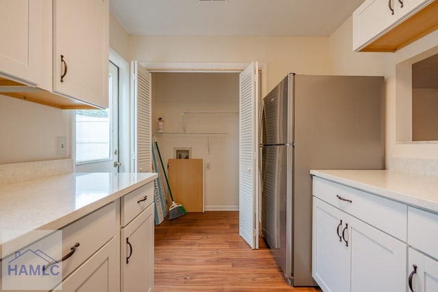 727S Main St Unit 121, Hinesville, GA 31313 - kitchen featuring freestanding refrigerator, light countertops, white cabinetry, and light wood finished floors