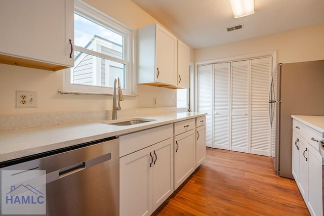 727S Main St Unit 121, Hinesville, GA 31313 - kitchen featuring stainless steel appliances, white cabinetry, light wood-type flooring, and light countertops