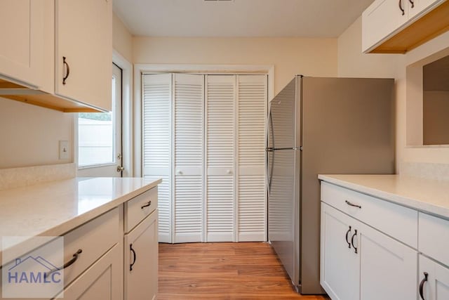 727S Main St Unit 121, Hinesville, GA 31313 - kitchen with light countertops, white cabinets, freestanding refrigerator, and light wood-type flooring