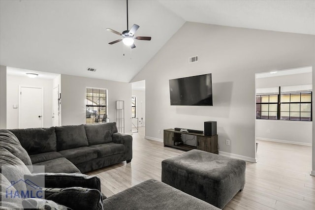 living room featuring ceiling fan, high vaulted ceiling, and light wood-type flooring