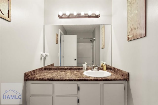 bathroom featuring a shower and vanity