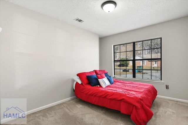 bedroom featuring light carpet and a textured ceiling