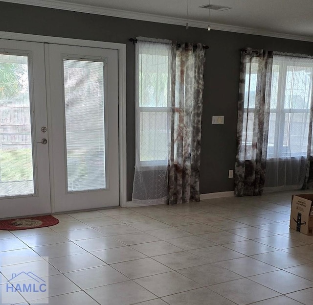 doorway featuring a healthy amount of sunlight, crown molding, french doors, and light tile patterned floors