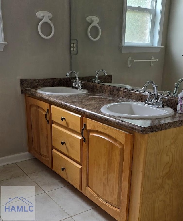bathroom with double vanity, tile patterned flooring, and a sink