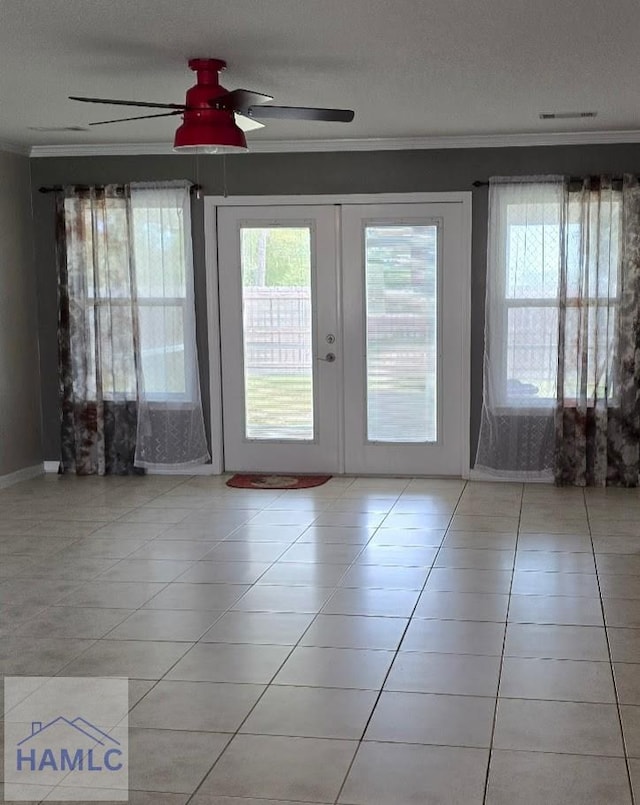 interior space with a textured ceiling, crown molding, ceiling fan, tile patterned floors, and french doors