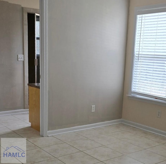 unfurnished room featuring light tile patterned floors and baseboards