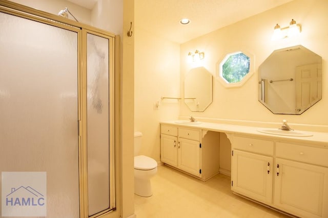 bathroom with vanity, toilet, and a shower with shower door