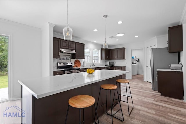 550 Brogdon Rd, Guyton, GA 31312 - kitchen with stainless steel appliances, under cabinet range hood, dark brown cabinetry, light wood finished floors, and ornamental molding