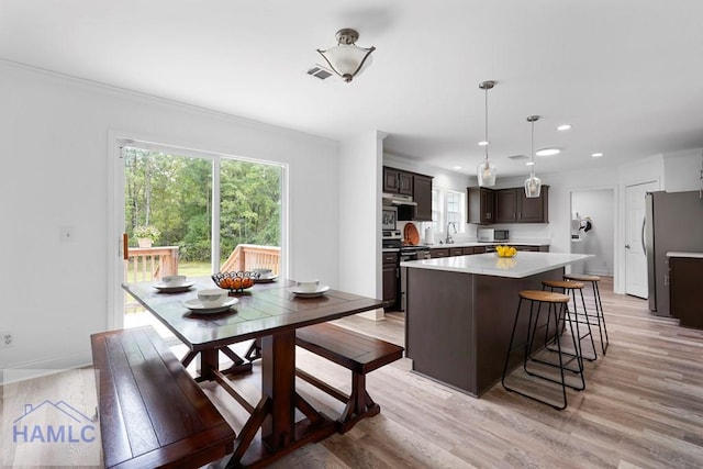 550 Brogdon Rd, Guyton, GA 31312 - kitchen featuring light countertops, freestanding refrigerator, light wood finished floors, a center island, and dark brown cabinetry