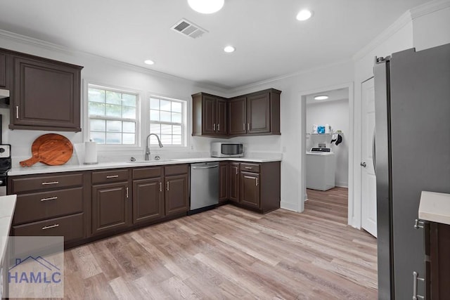 550 Brogdon Rd, Guyton, GA 31312 - kitchen with appliances with stainless steel finishes, a sink, washer / clothes dryer, light countertops, and dark brown cabinetry