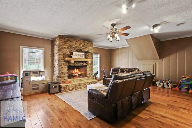 645 Littlefield St, Jesup, GA 31546 - living area featuring wood-type flooring, a textured ceiling, crown molding, a ceiling fan, and a fireplace